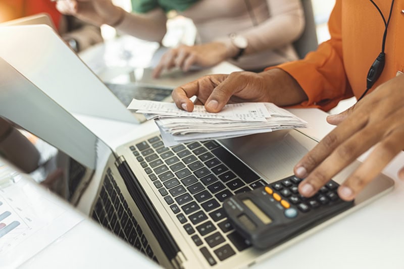 A person paying bill in front of laptop.