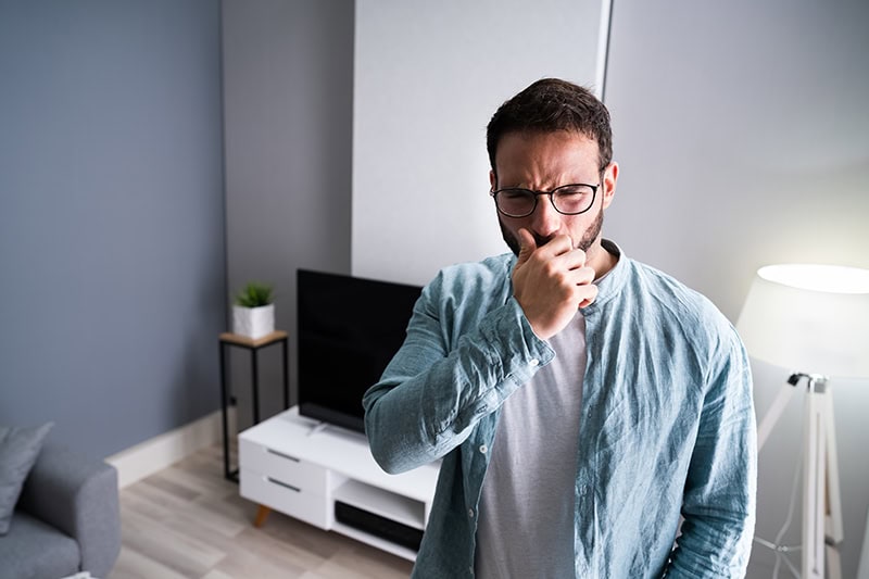 A man holding his nose.